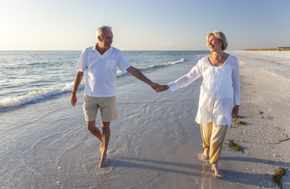 senior couple walking on the beach