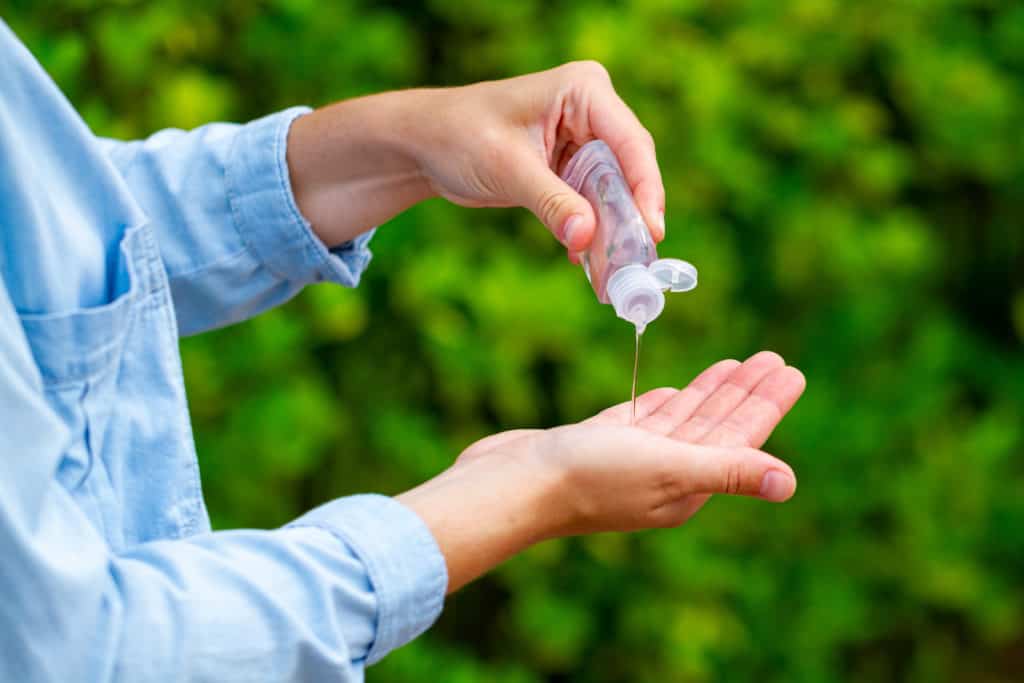 Close up of a woman applying hand sanitizer onto her hand.
