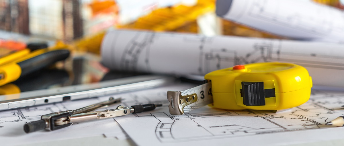 close up of a tape measure with blueprints