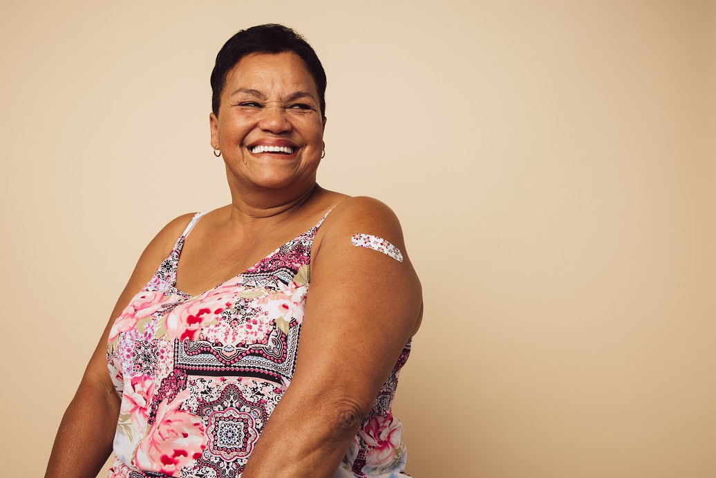 Older woman smiling after receiving vaccines