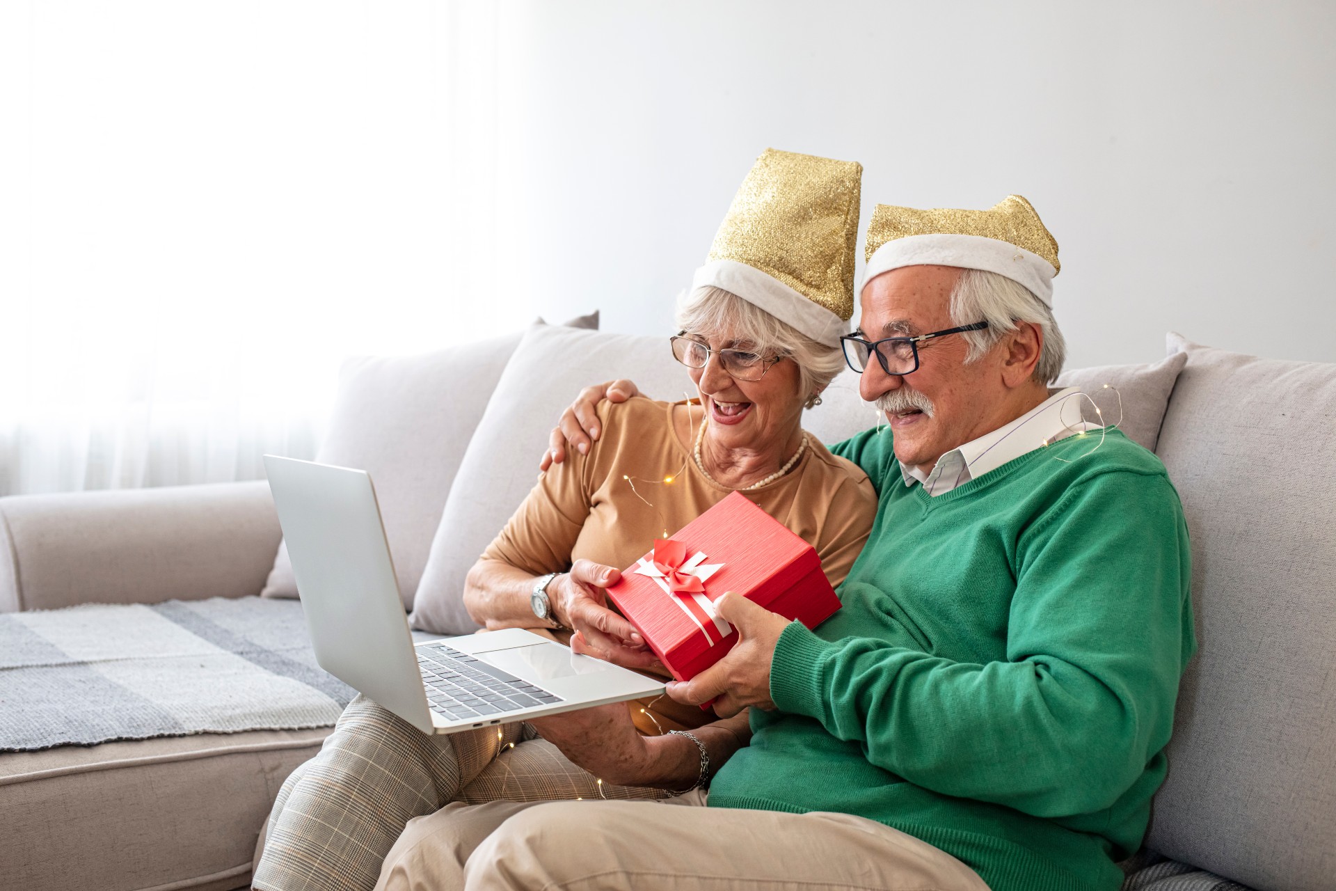 Senior couple using a laptop together on a couch