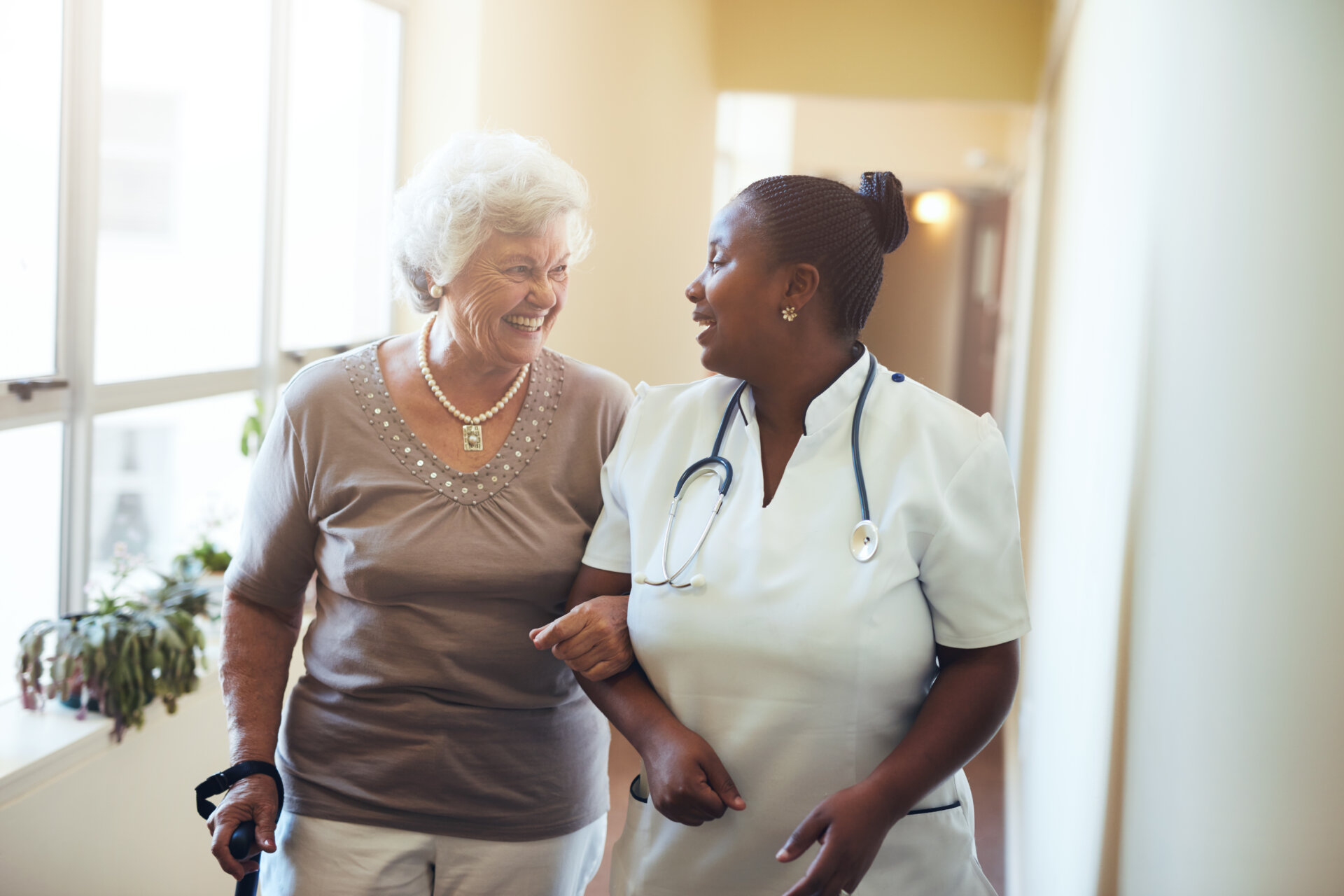 woman smiling and walking with nurse