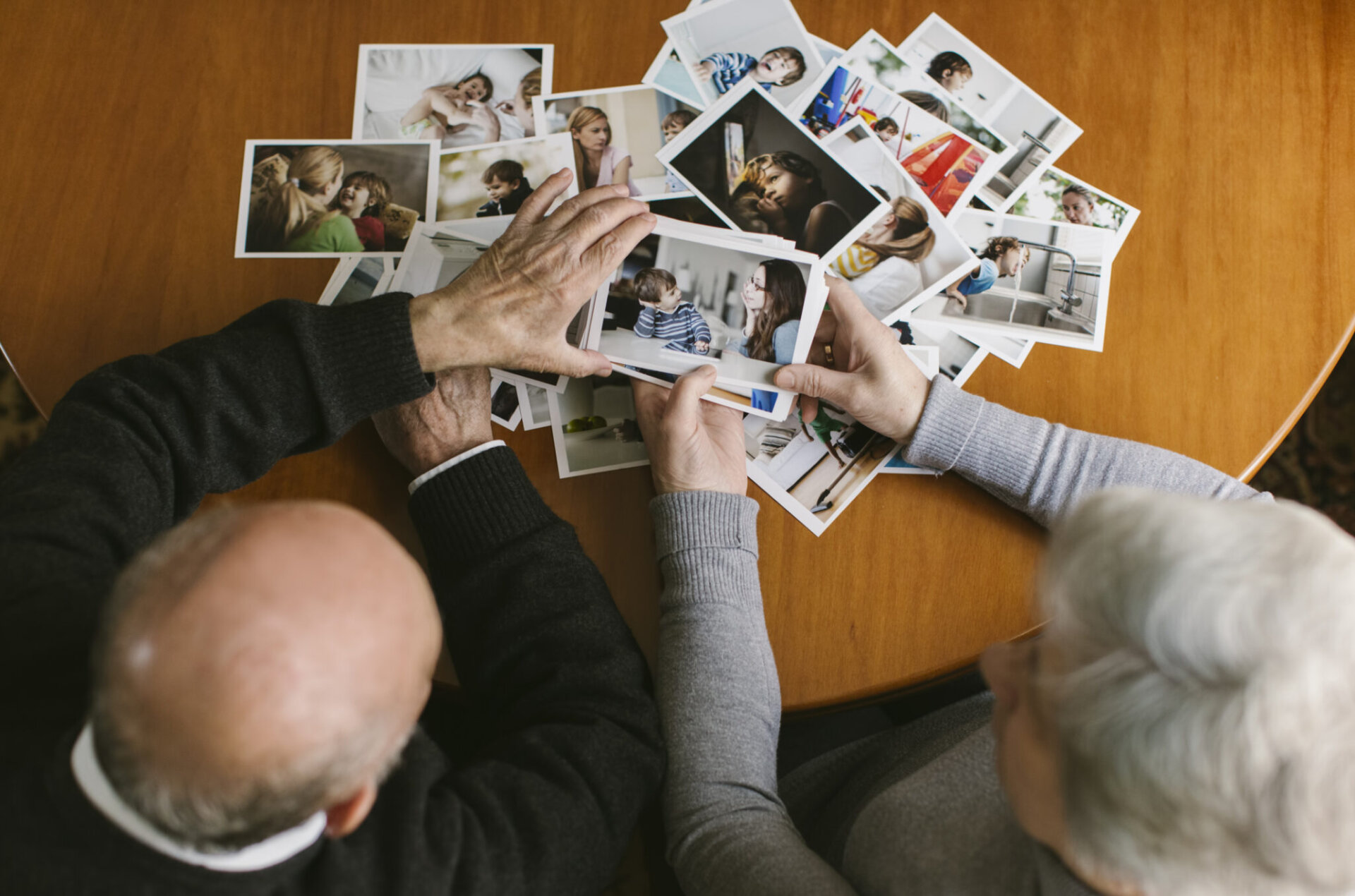 A top down image of a couple looking at polaroids