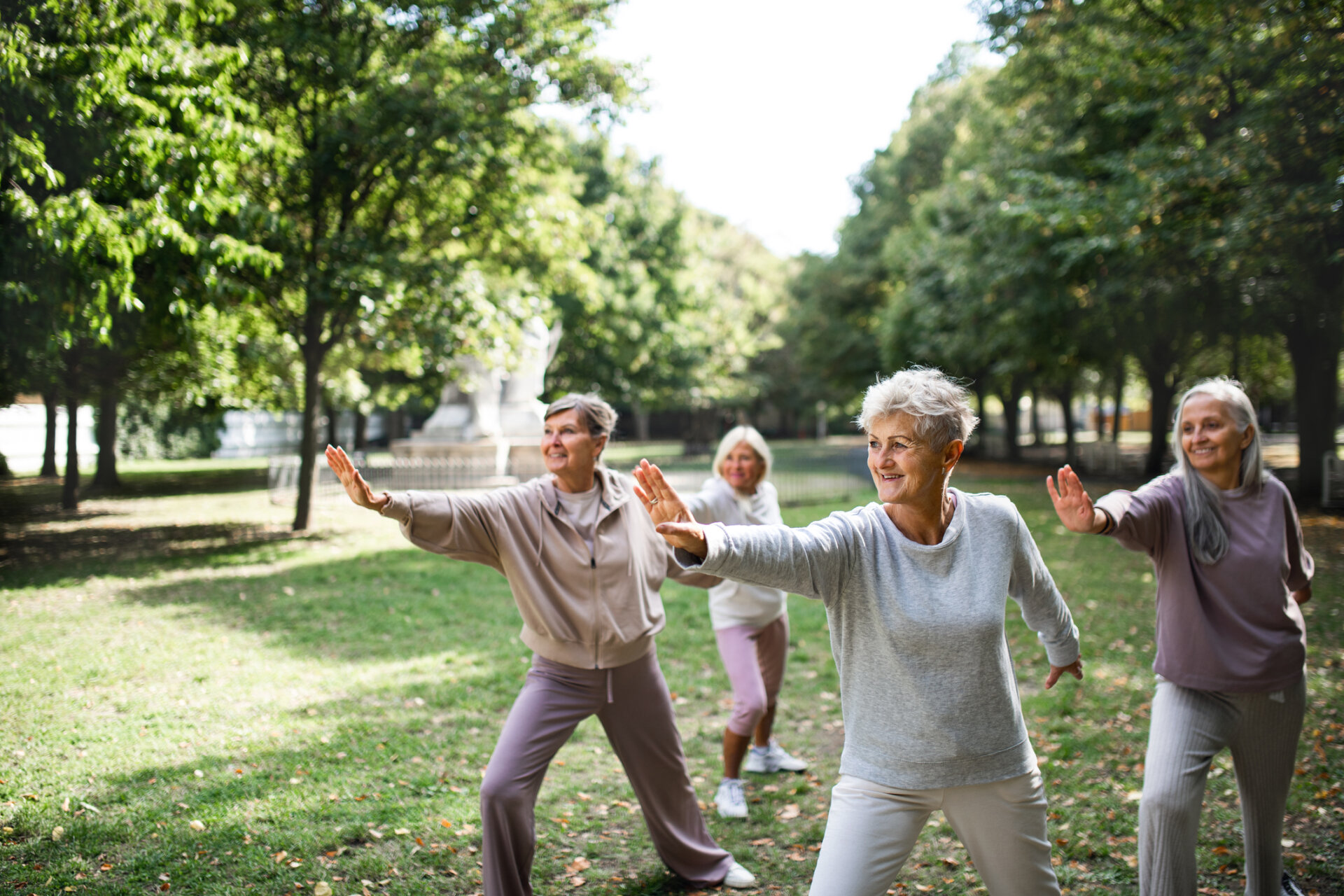 A group of senior women practicing yoga outdoors