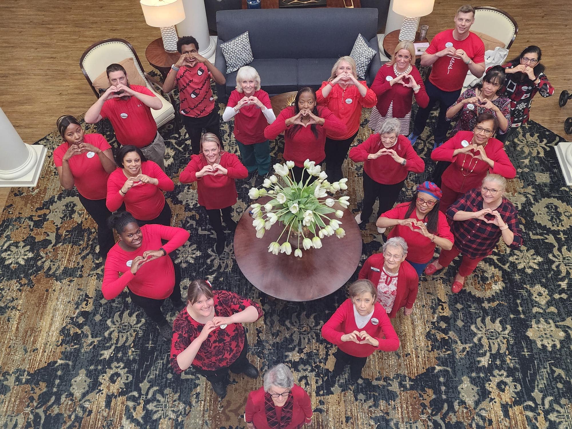 Group of people wearing read and making hearts with their hands