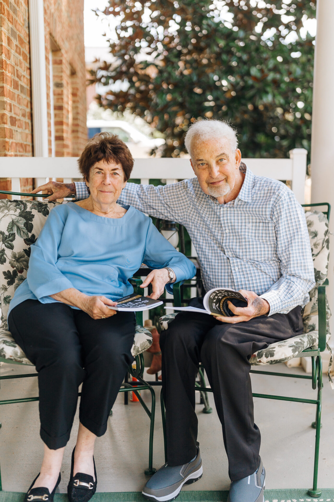Senior couple sitting on porch and reading