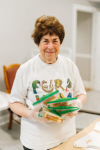 Senior volunteer holding sandwiches