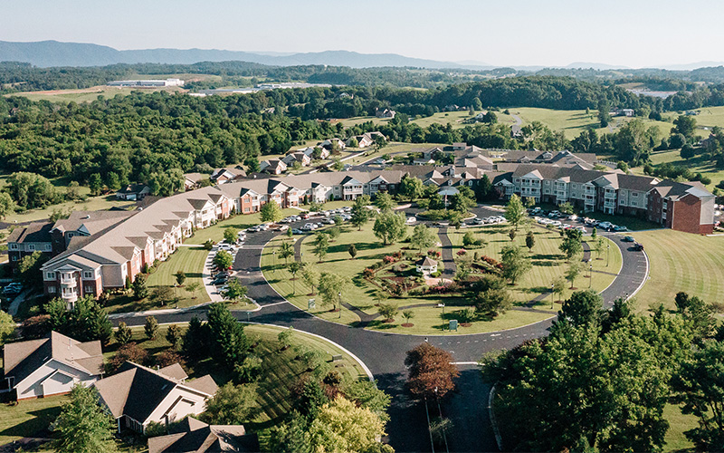 Aerial view of a sprawling senior community with circular driveway and landscaped gardens.