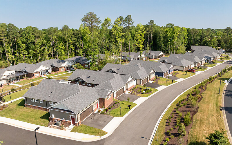 Aerial View of Residential Units in a Senior Living Community Aerial view of a senior living community with multiple residential units and lush green surroundings.
