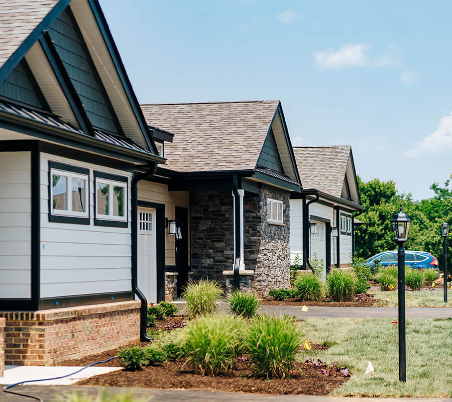 Charming bungalow-style units with landscaped front yards in residential community.