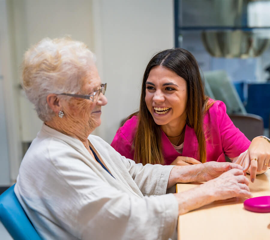 Senior woman and caregiver have a fun interaction