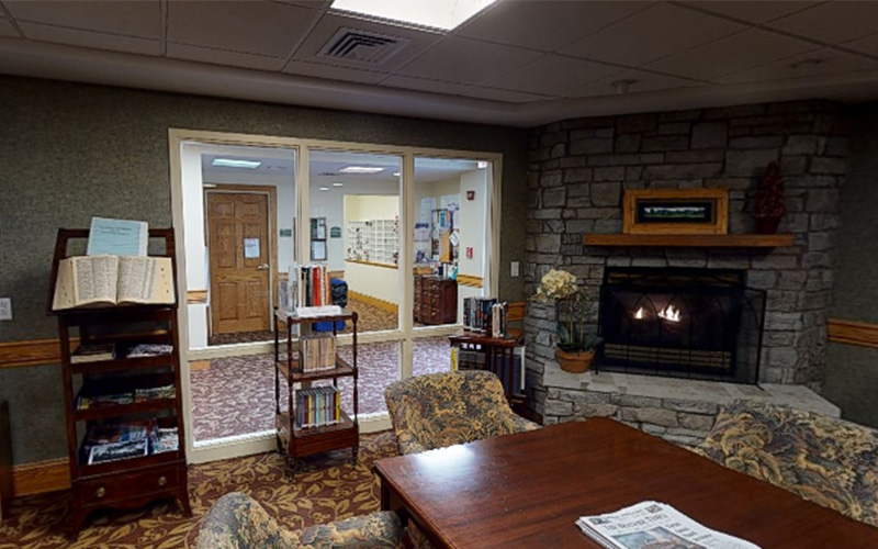 Cozy reading room with fireplace in a senior community center.