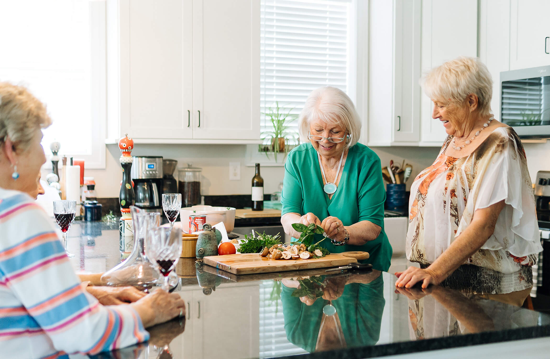 Residents enjoying a cooking activity in a modern kitchen at a senior living community.