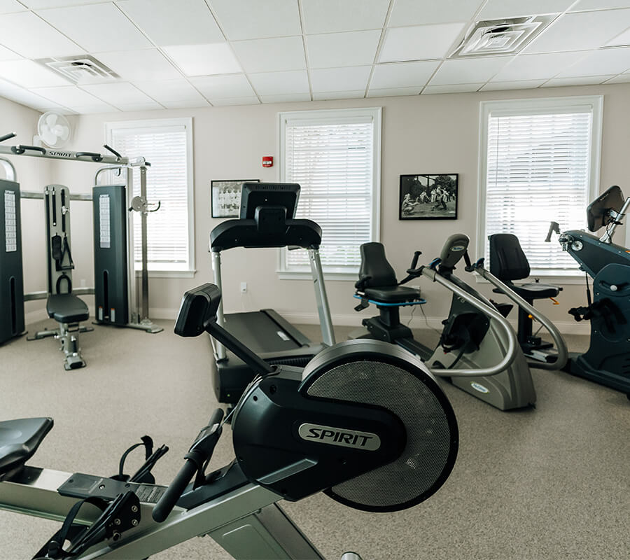 Modern gym with exercise equipment in a bright, spacious room.