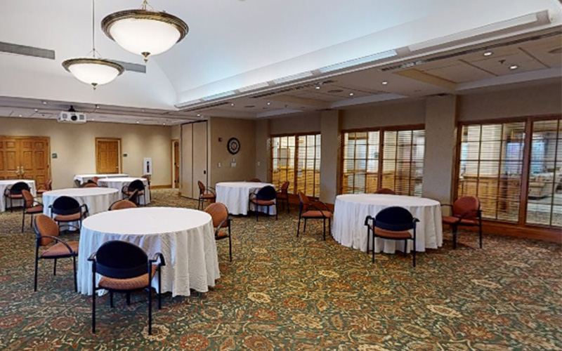 Community Room in Senior Living Facility Spacious community room with round tables and chairs in a senior living facility.