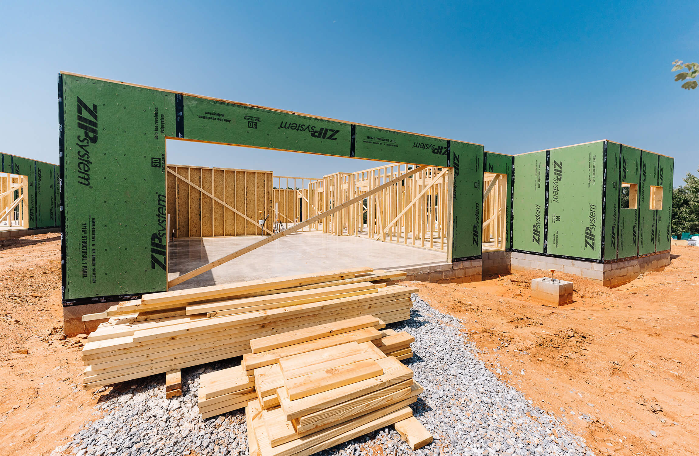 Framing of new units under construction with wood panels and exposed framework.