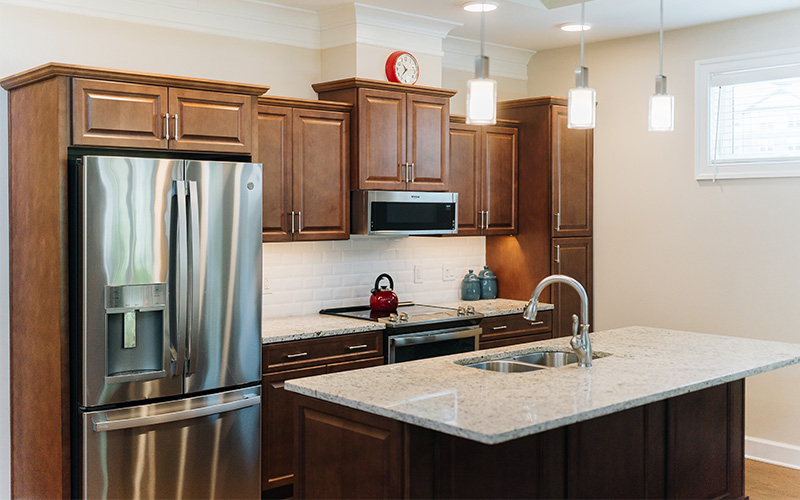 Contemporary Kitchen Design in Residential Unit Modern kitchen with wooden cabinetry, stainless steel appliances, and pendant lighting.