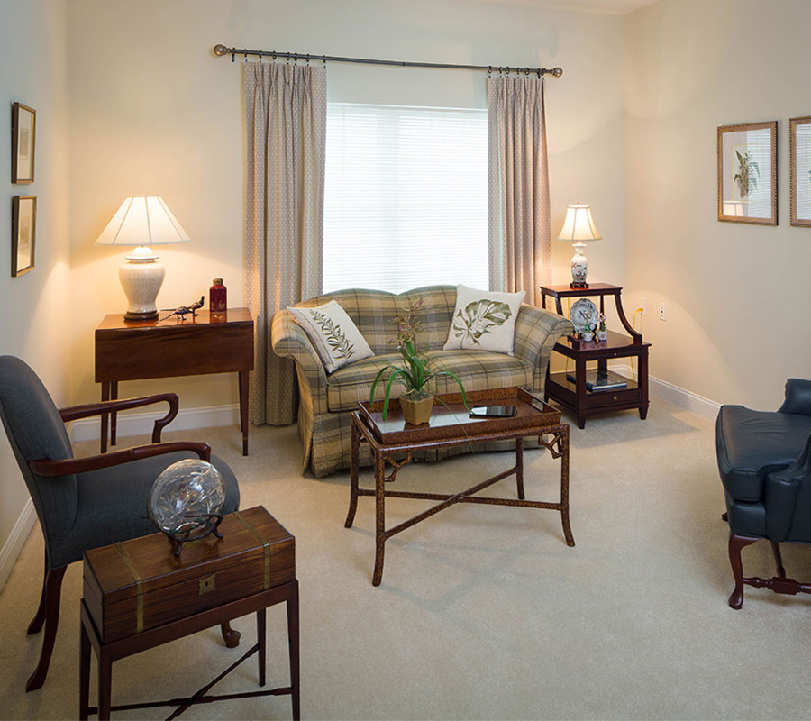 Cozy living area with plaid sofa, armchairs, and decorative lamps.