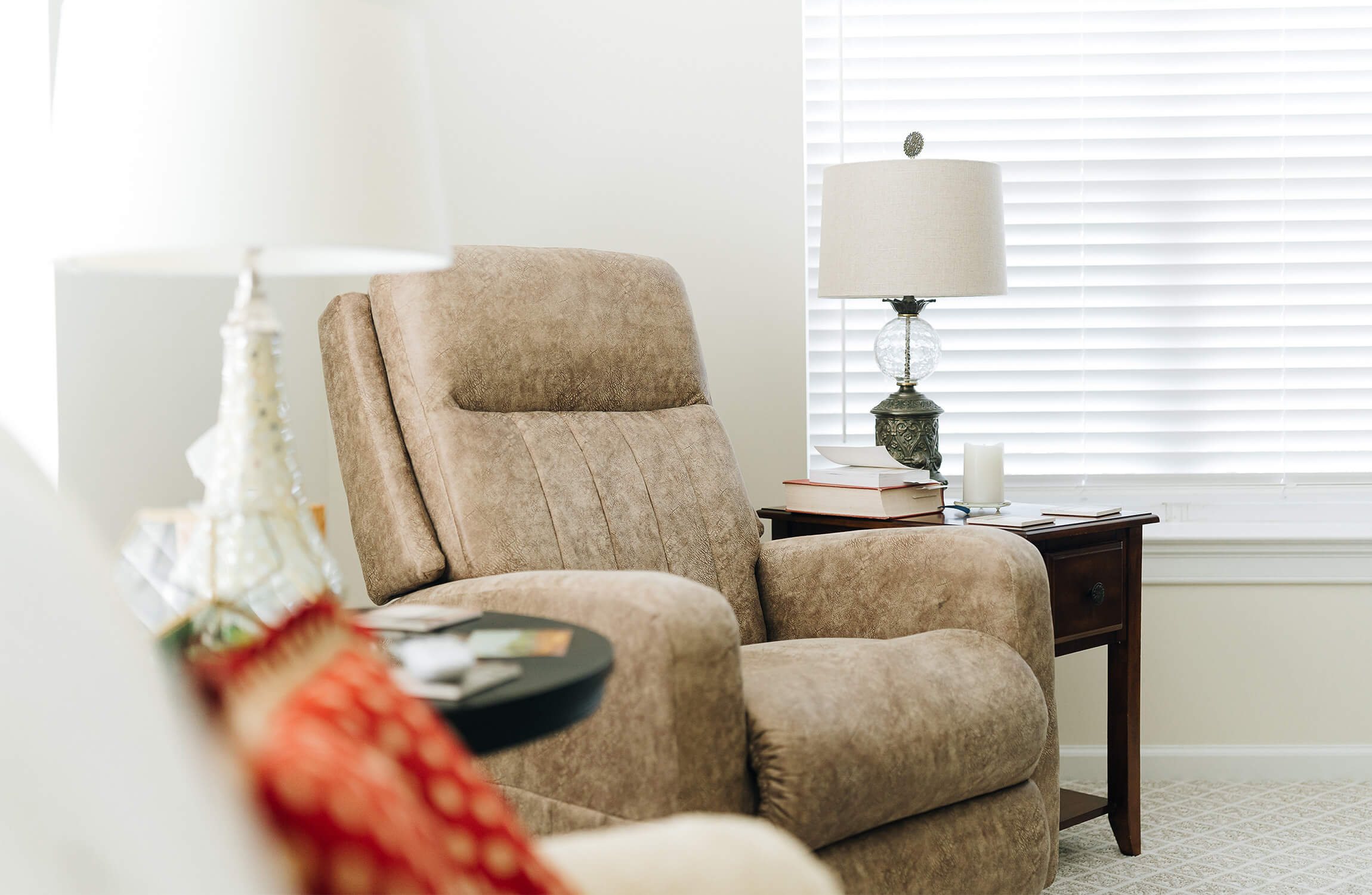 Cozy senior living unit with armchairs, a window view, and decorative art.