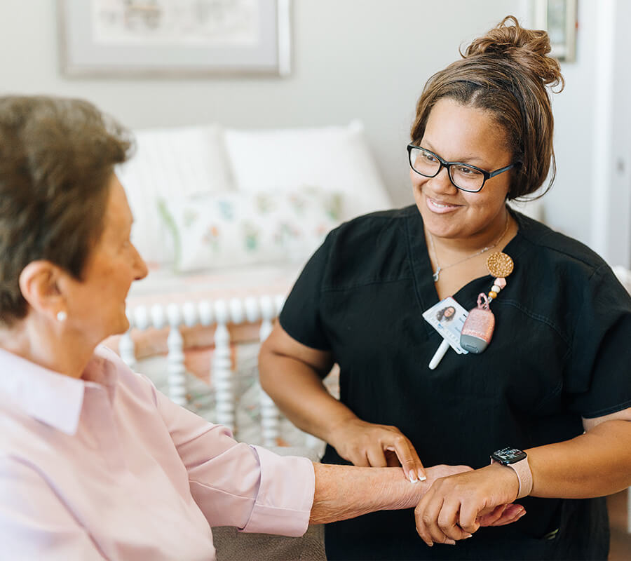 Senior resident and nurse taking pulse for wellness