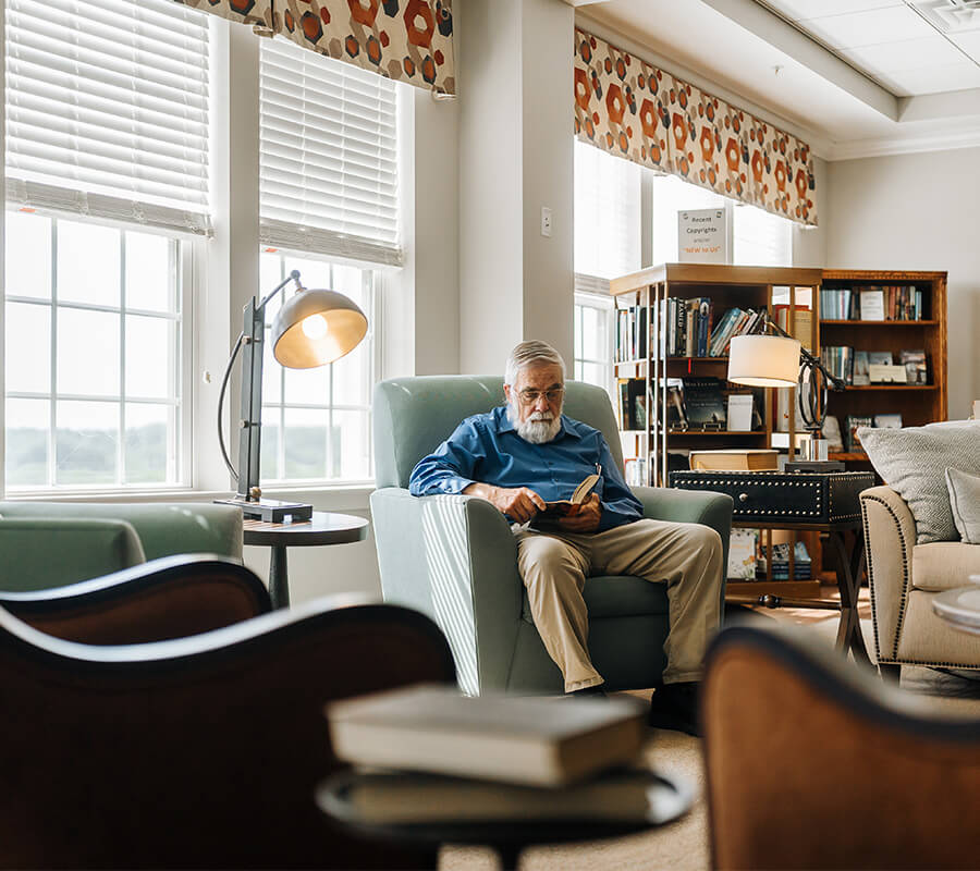 Resident sitting and reading in community library