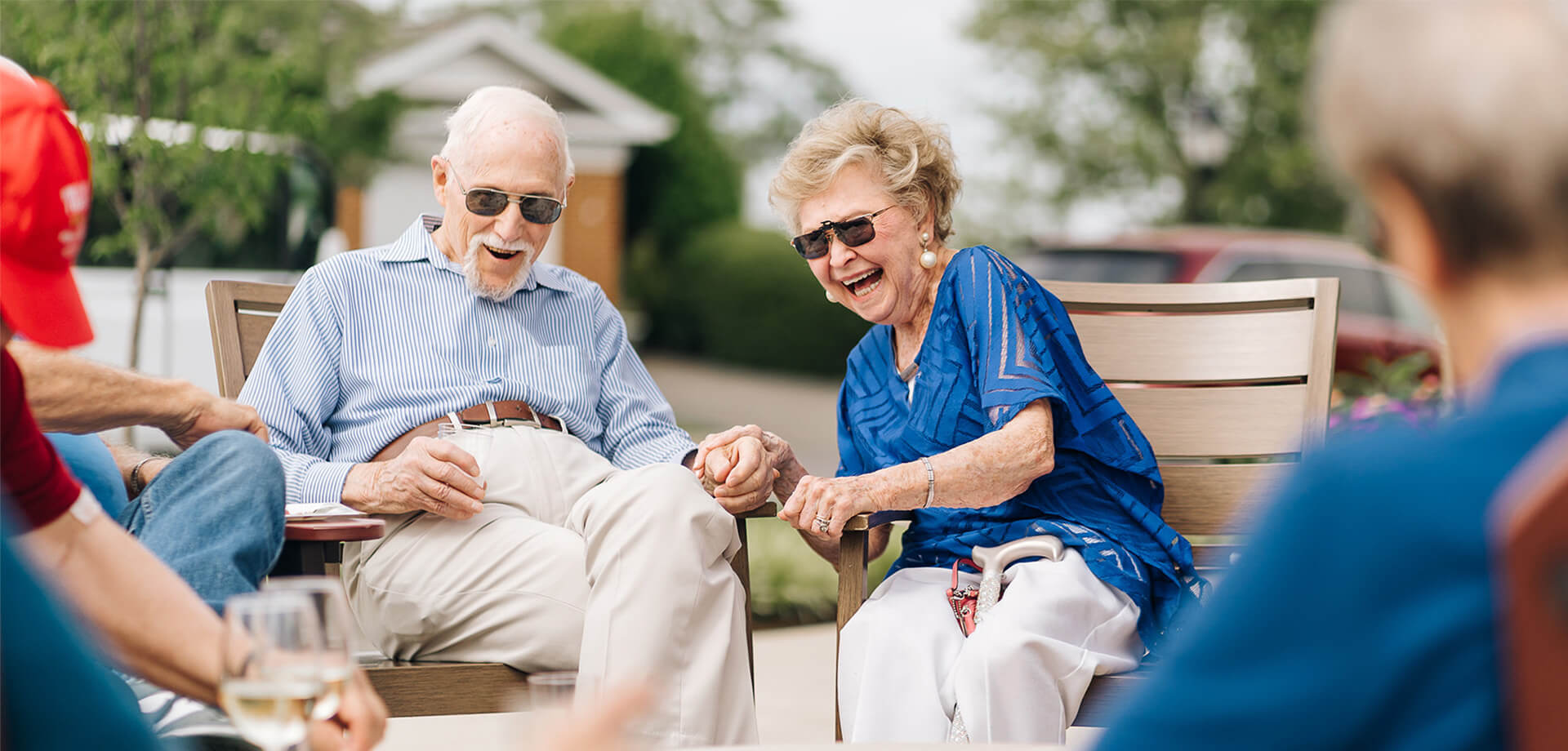 The Culpeper senior couple laughing outdoors with friends