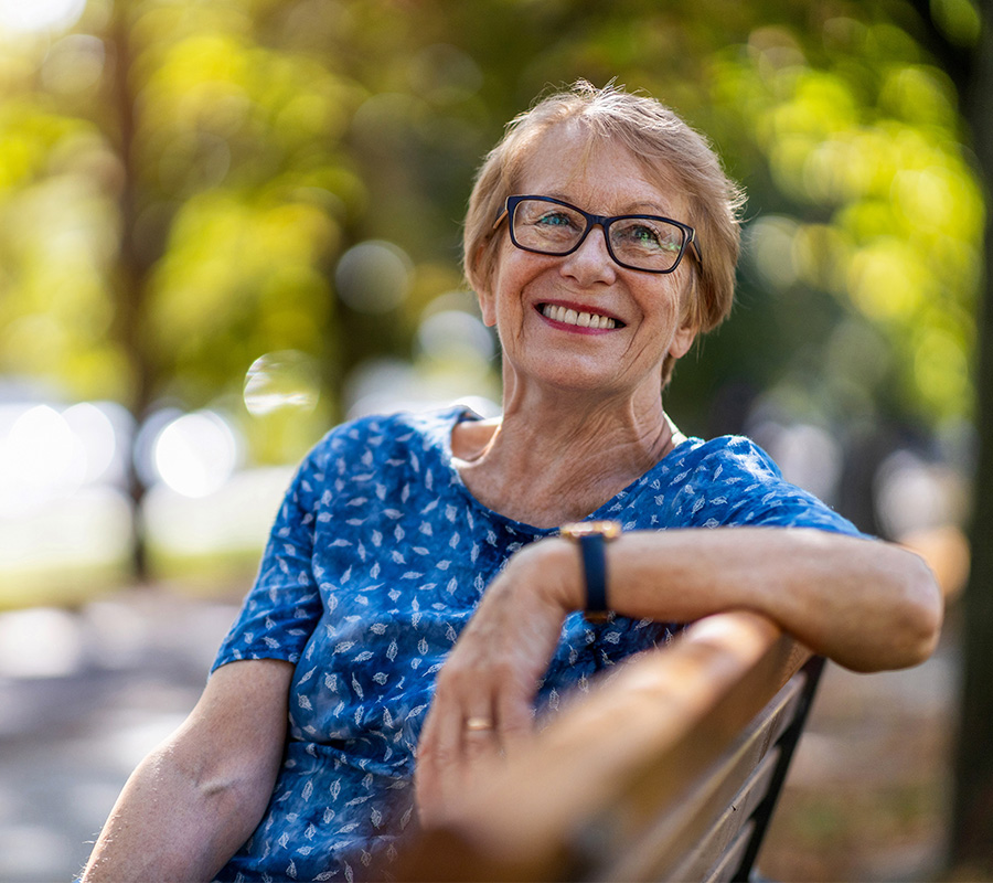 Happy elderly woman relaxing on bench
