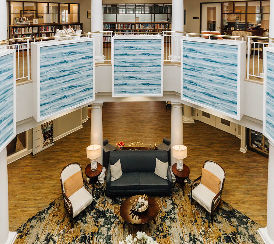 Spacious interior common area with seating and large blue art panels on the walls.