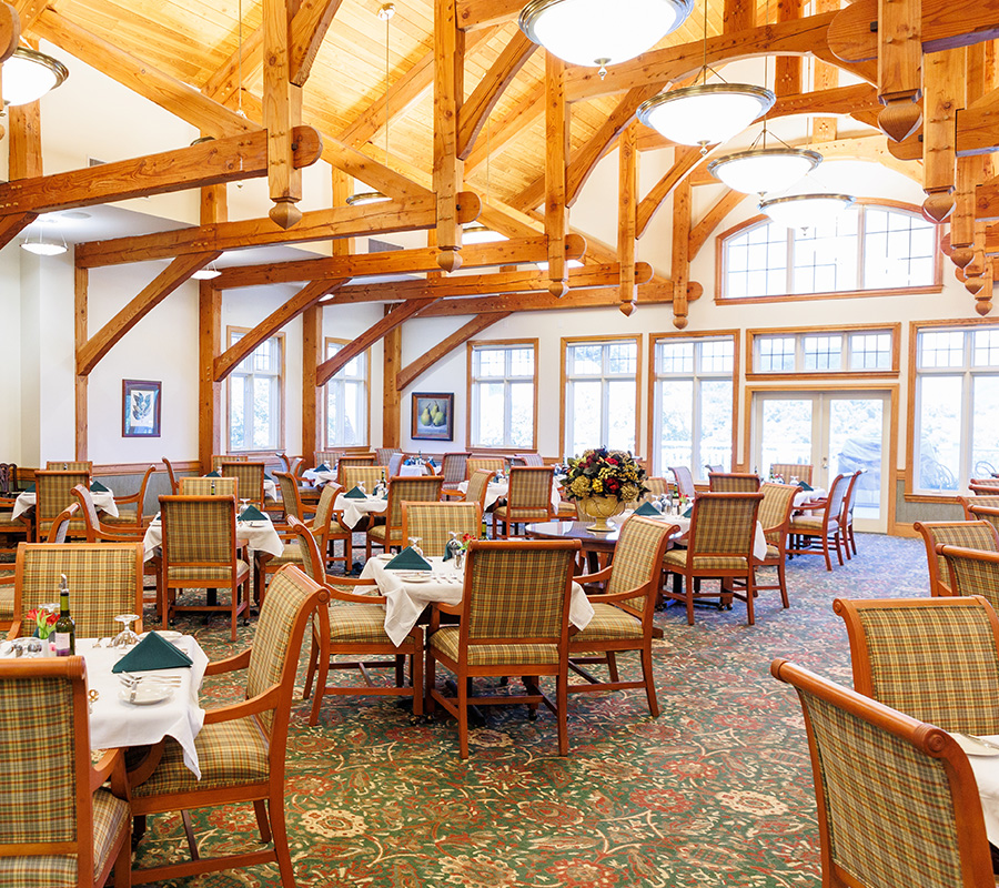 Elegant Dining Area with Wooden Beams Spacious dining area with wooden beams and set tables in a community unit.