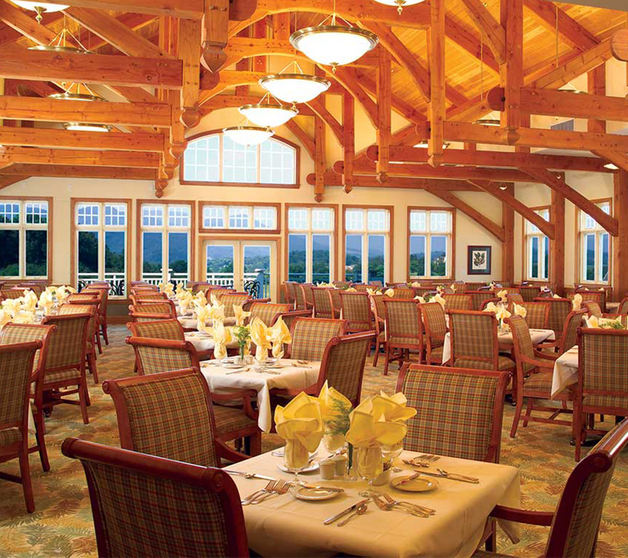 Spacious dining room with wooden beams and neatly arranged tables.