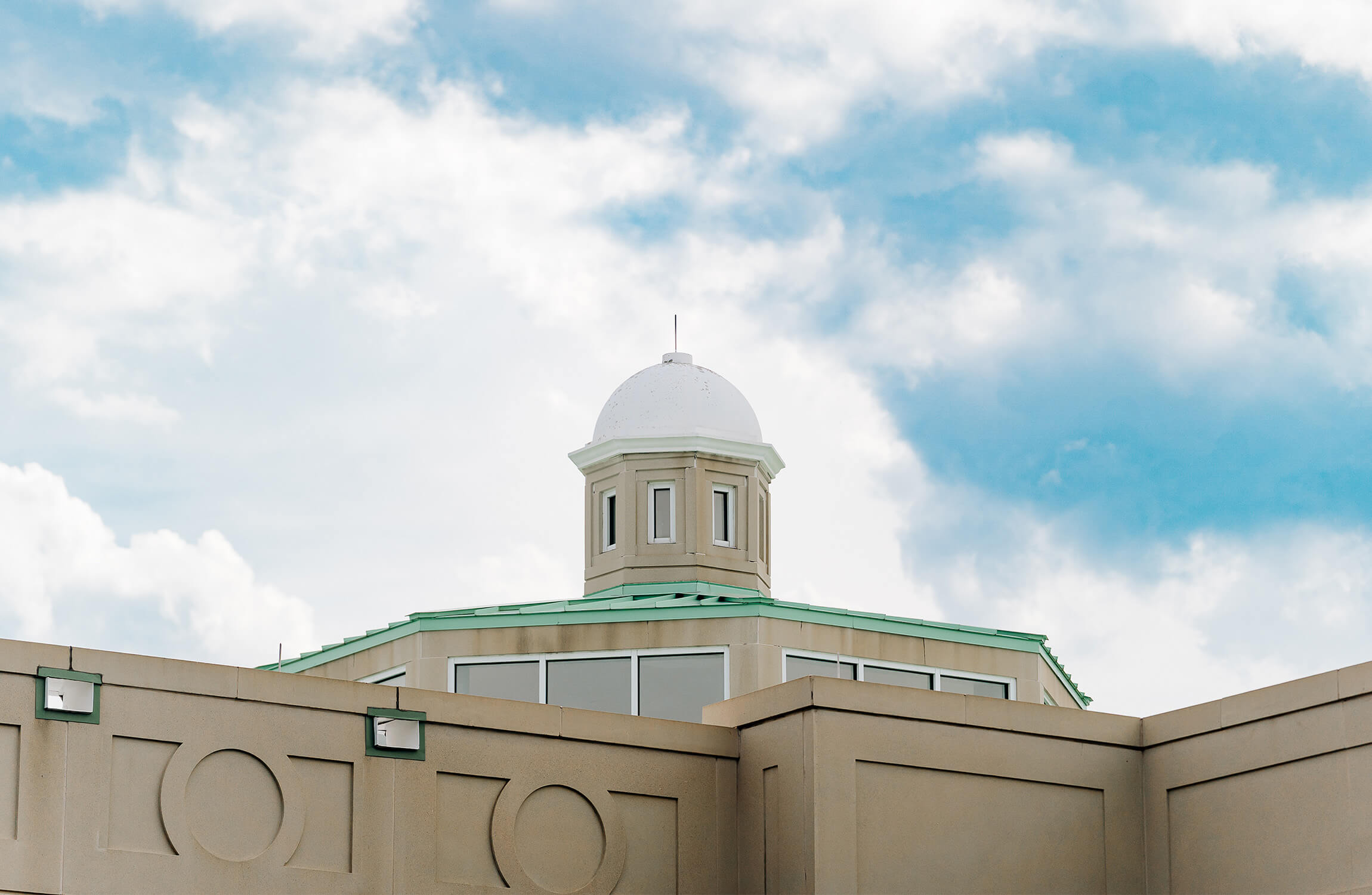 Elegant dome atop a senior living community with a blue sky background.