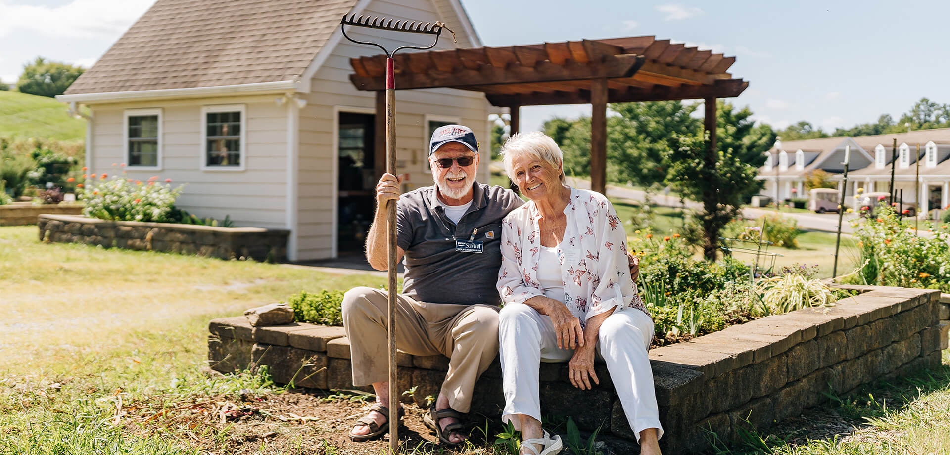 Elderly couple sitting outside, enjoying a sunny day in a community garden.