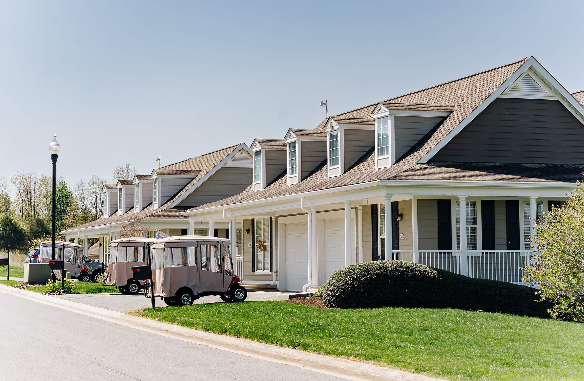 Row of modern independent living units with golf carts parked outside.