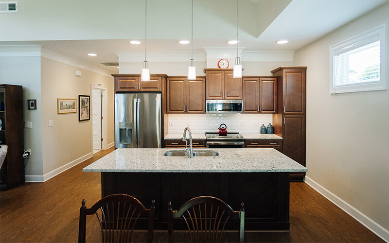 Elegant Kitchen in Living Unit Modern kitchen with granite island and wooden cabinets in a living unit.