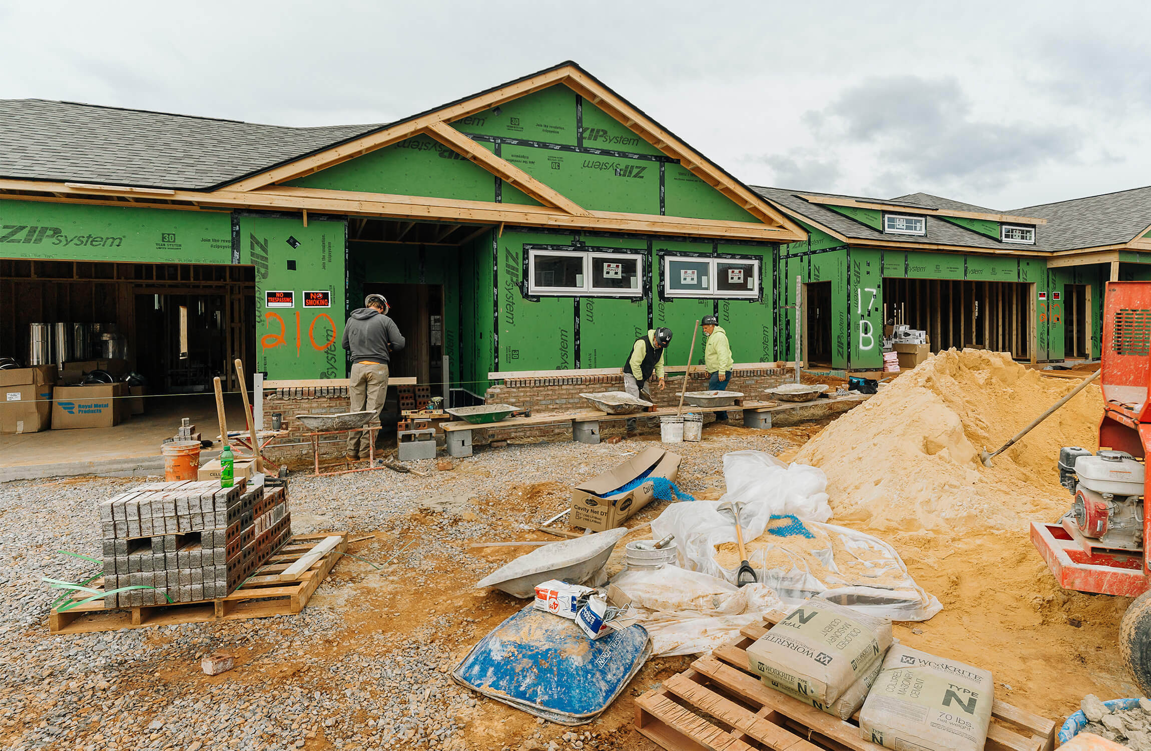 Construction workers building new units in green-paneled senior living facility.