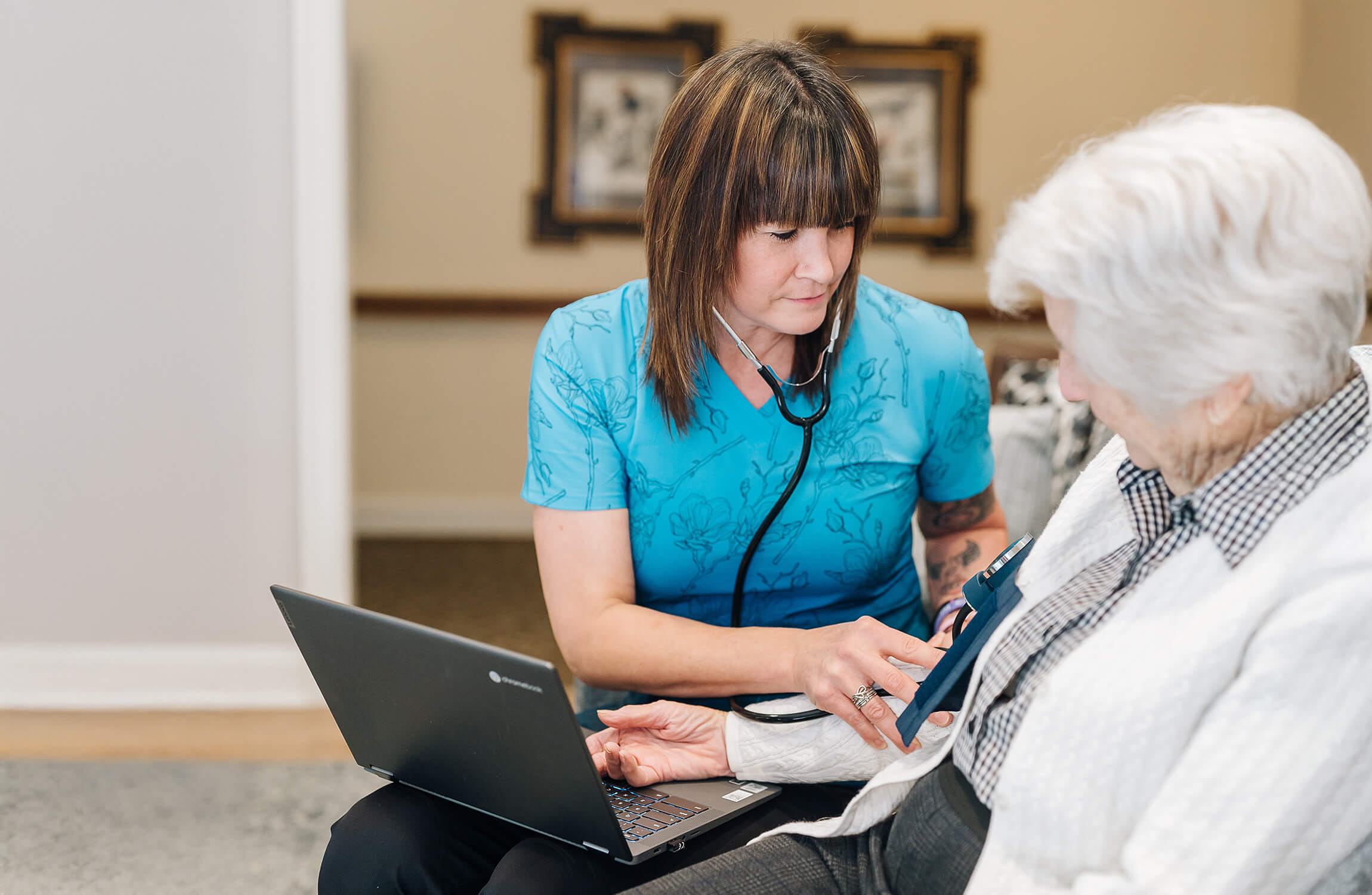Nurse using a stethoscope on a senior woman in a community unit.