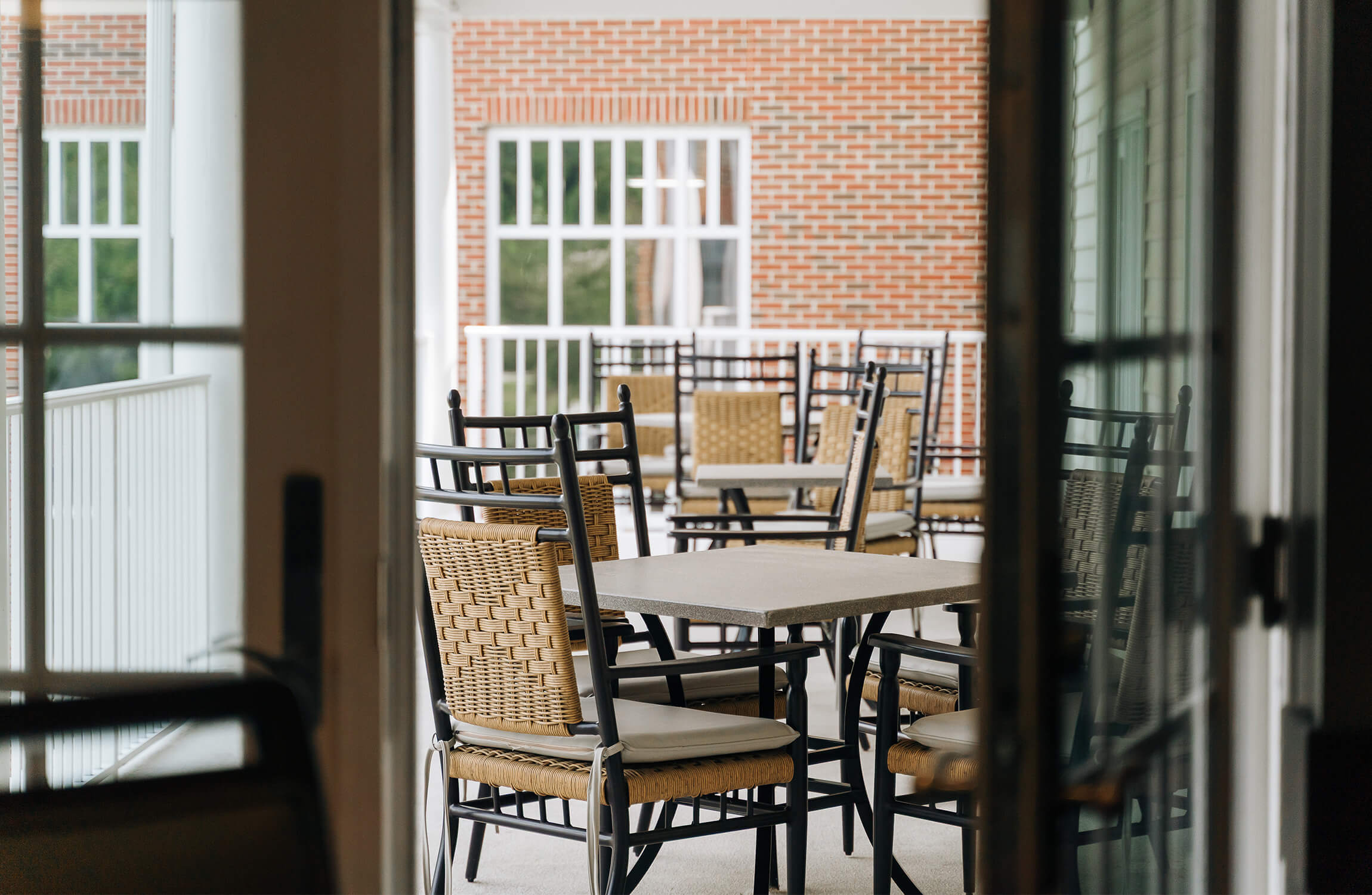 Outdoor patio with wicker chairs and tables at a community living space.
