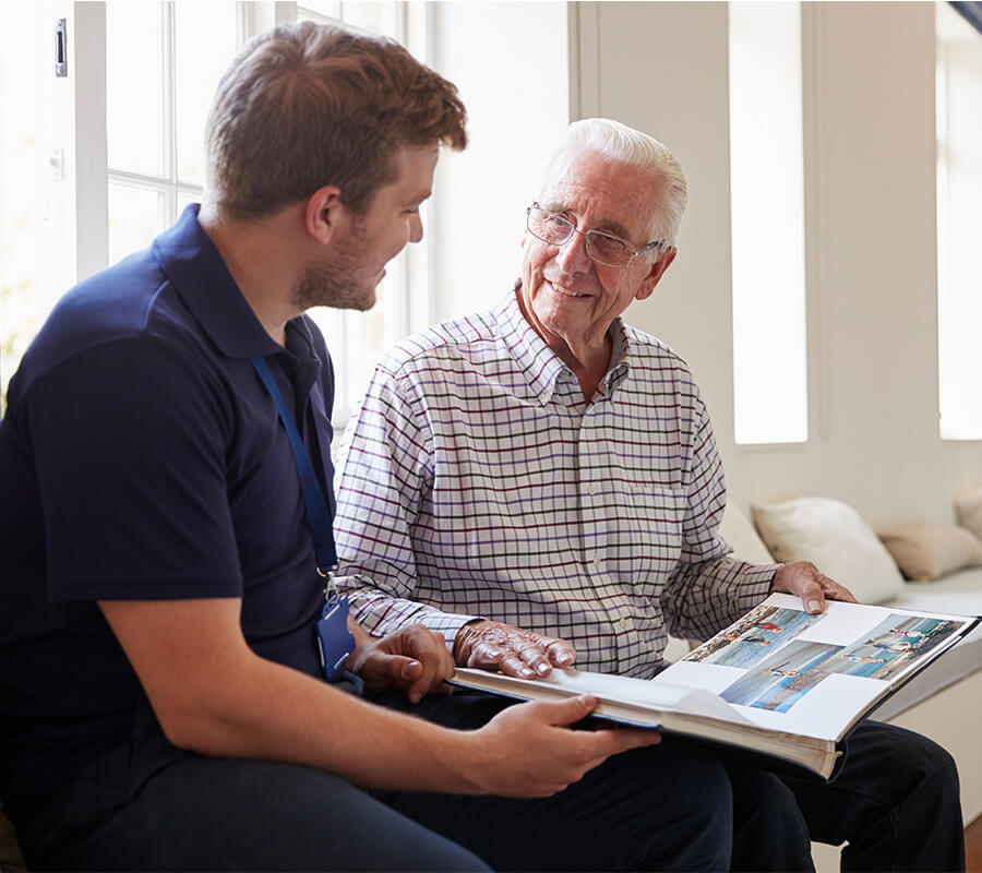 Senior man and young man look through photo album