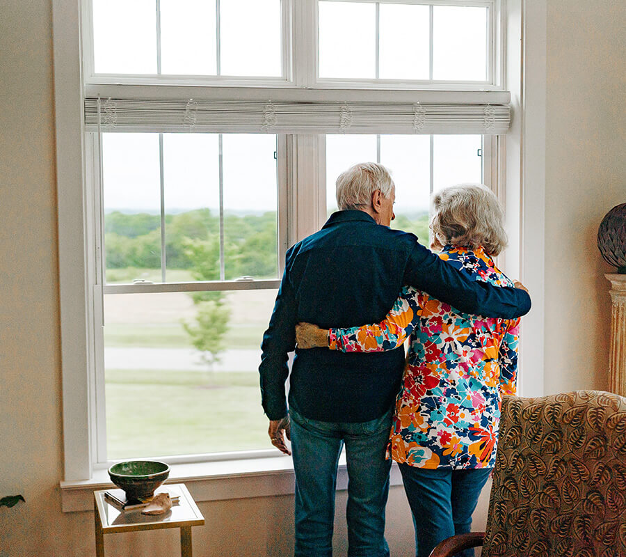Senior couple looking out their window