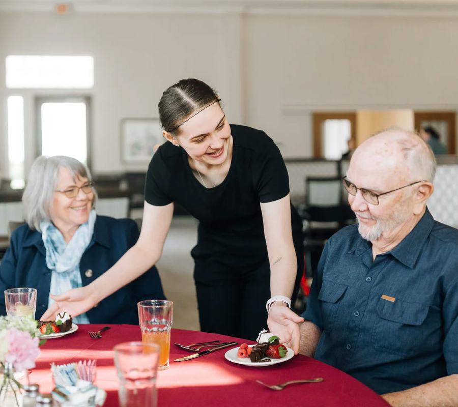 Senior couple being served dessert