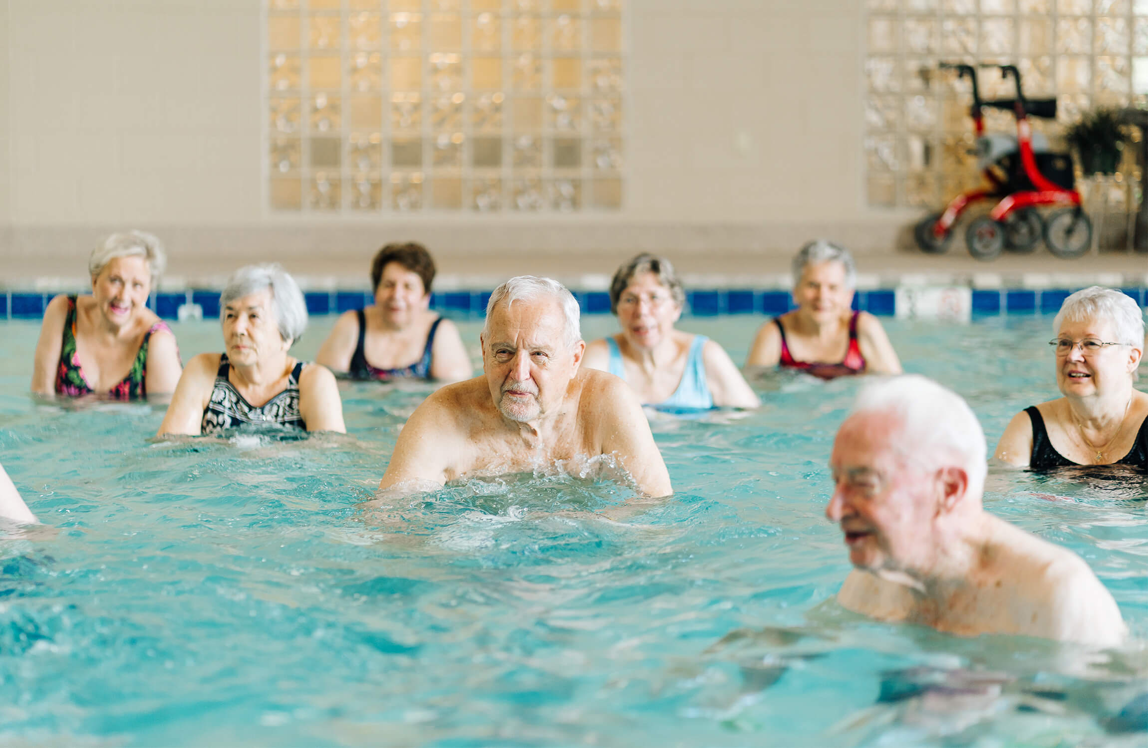 Seniors participating in a water exercise at a community pool.