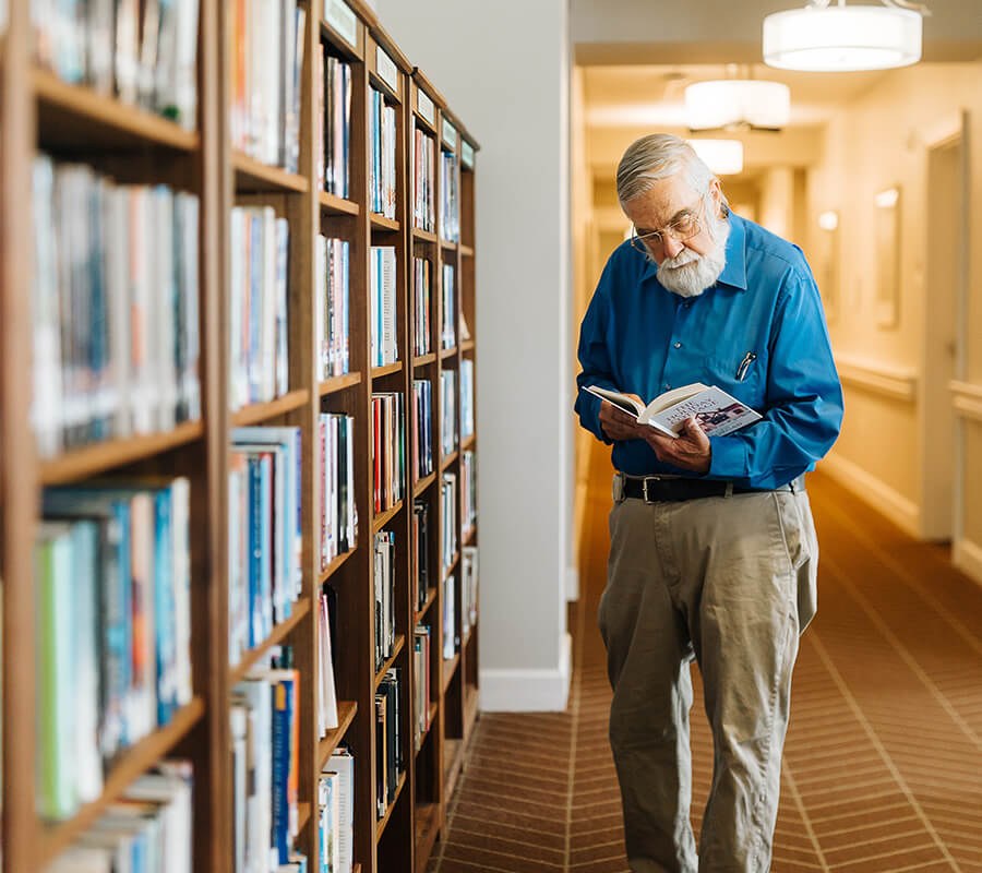 Senior man reads in community library
