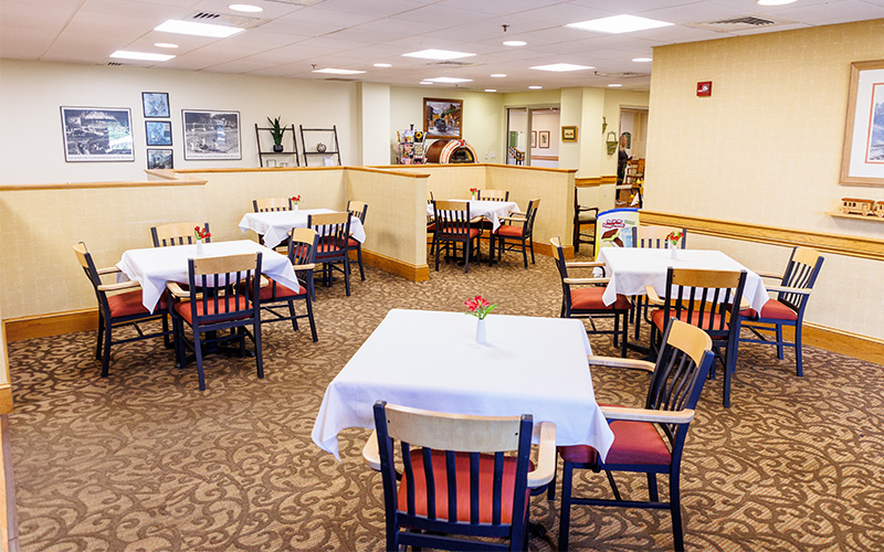 Cozy Dining Area for Residents Dining area with several tables and chairs in a senior living community setting.