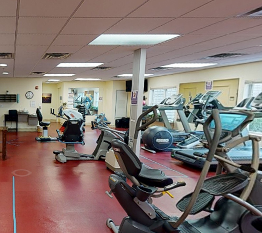 Exercise room with cardio equipment in a senior living community.