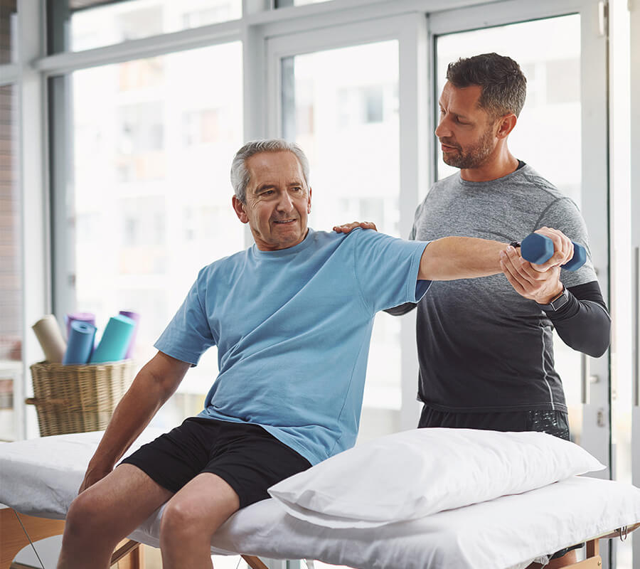Senior man and physical therapist work out