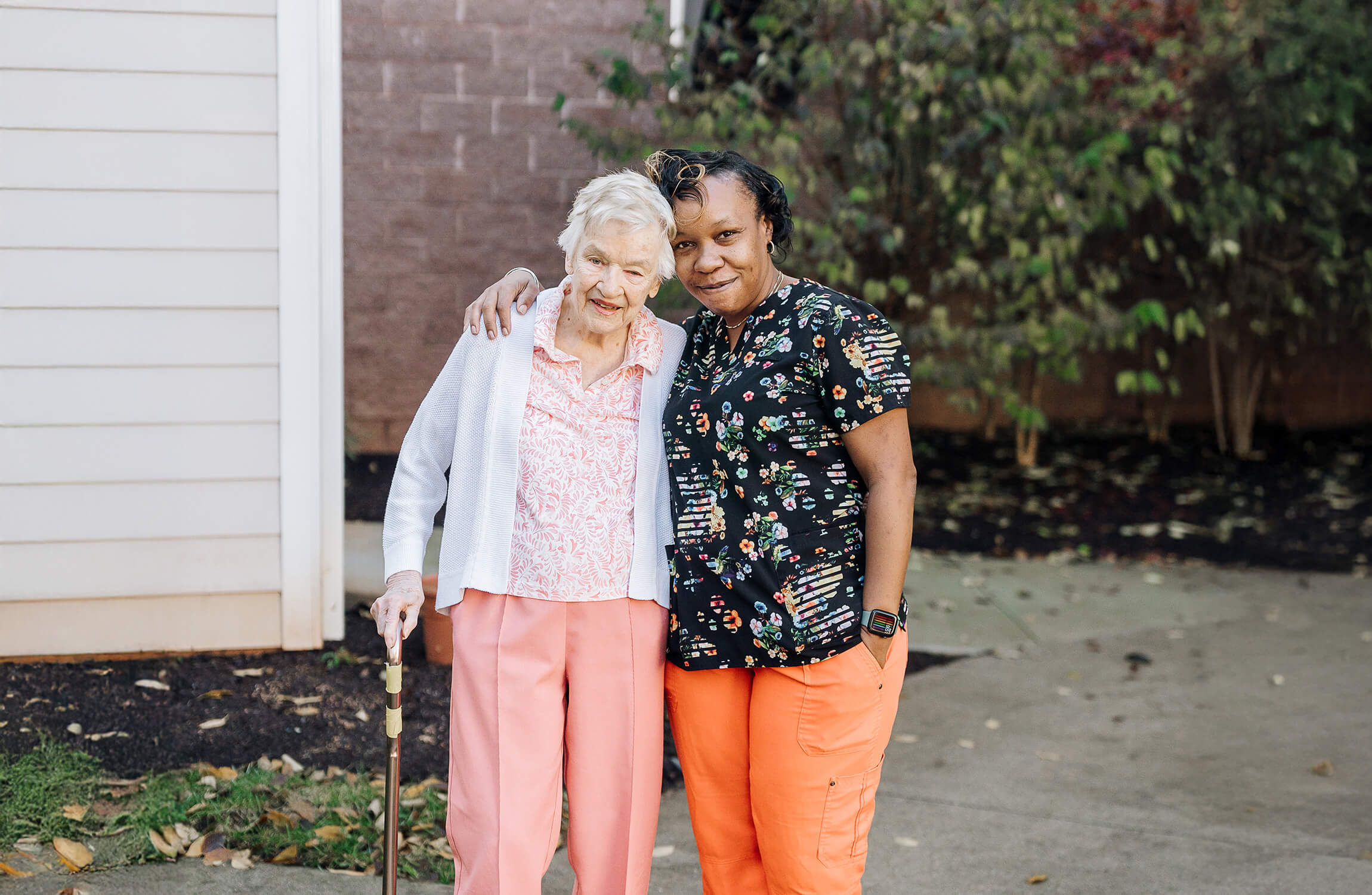 The Summit senior and caregiver smiling and hugging