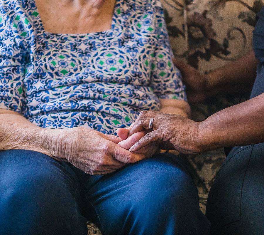 Senior woman holding hands with caregiver