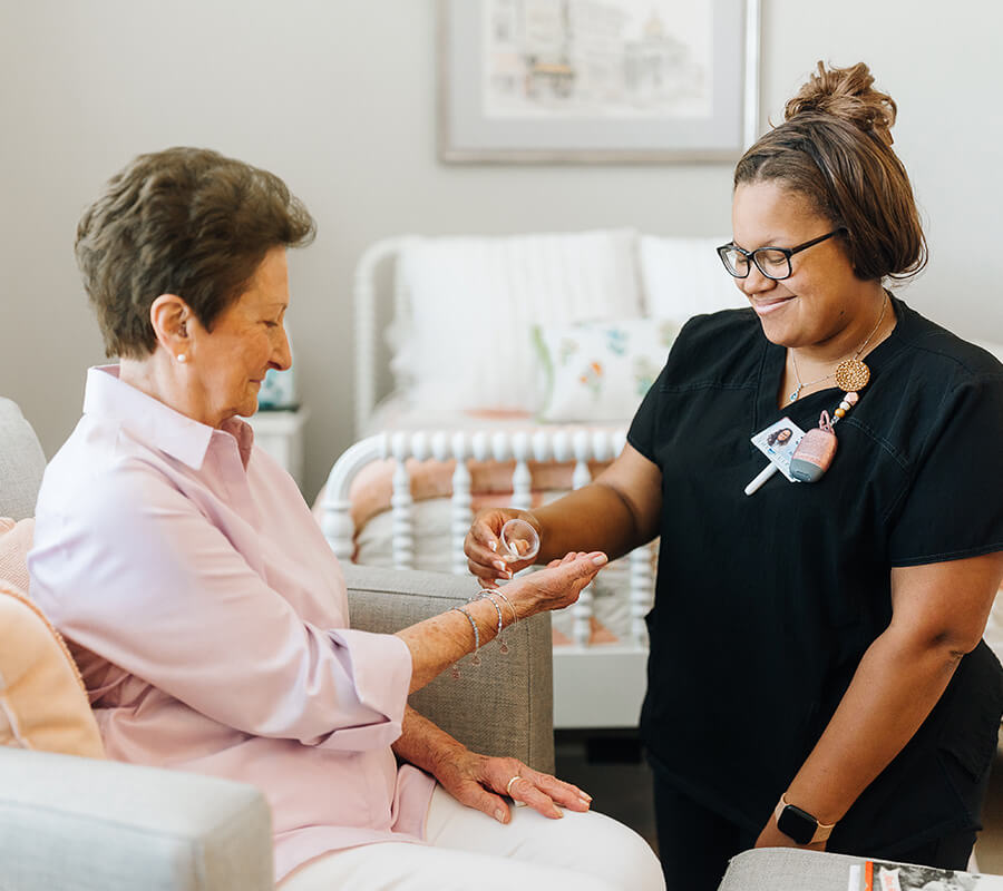 Senior woman getting medicine from nurse
