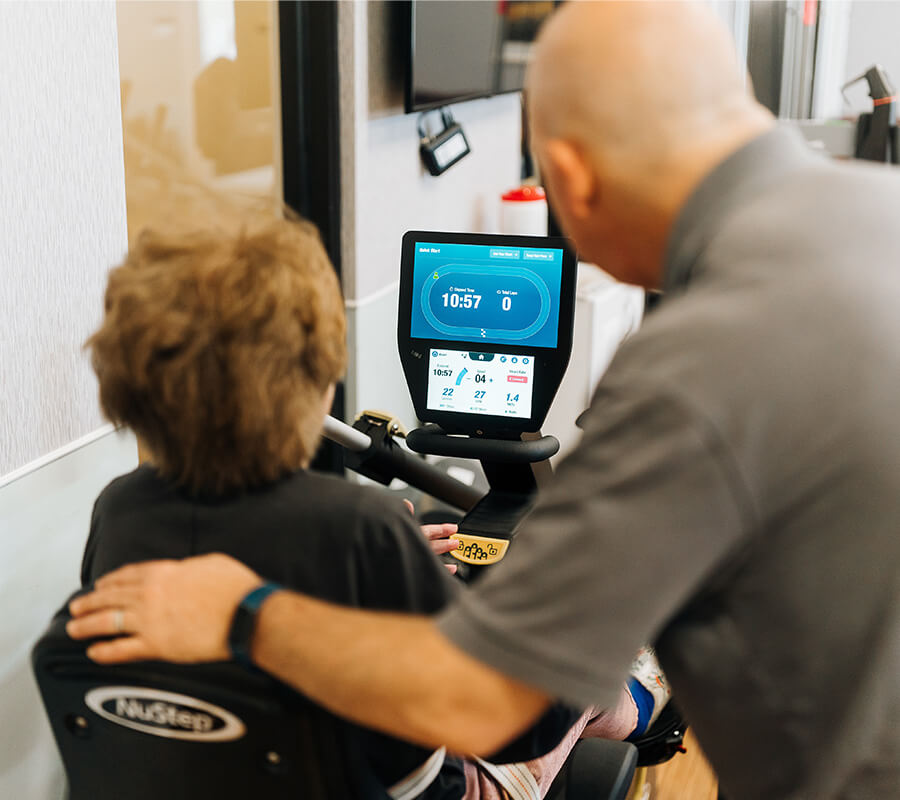 Senior woman and physical therapist using stationary bike