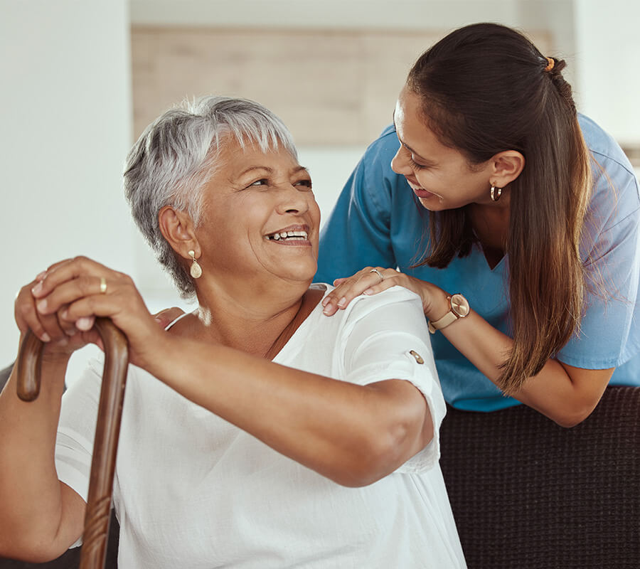 Senior woman and nurse smile in home